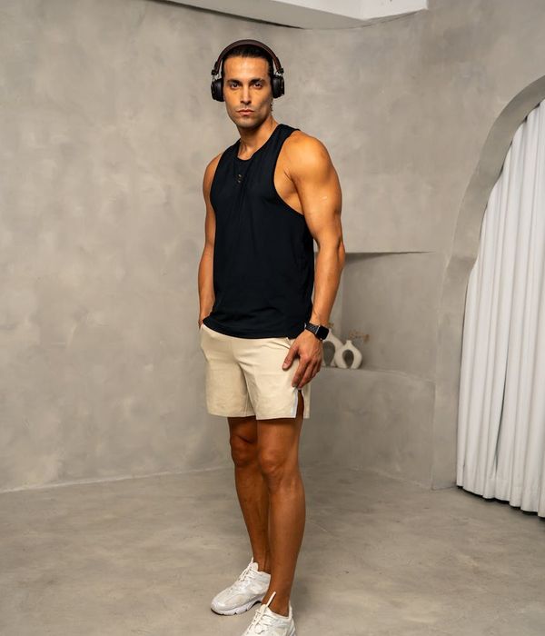 Man in a focused athletic stance in a minimalist setting.